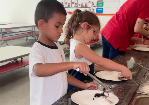 crianças servindo o próprio prato nas refeições